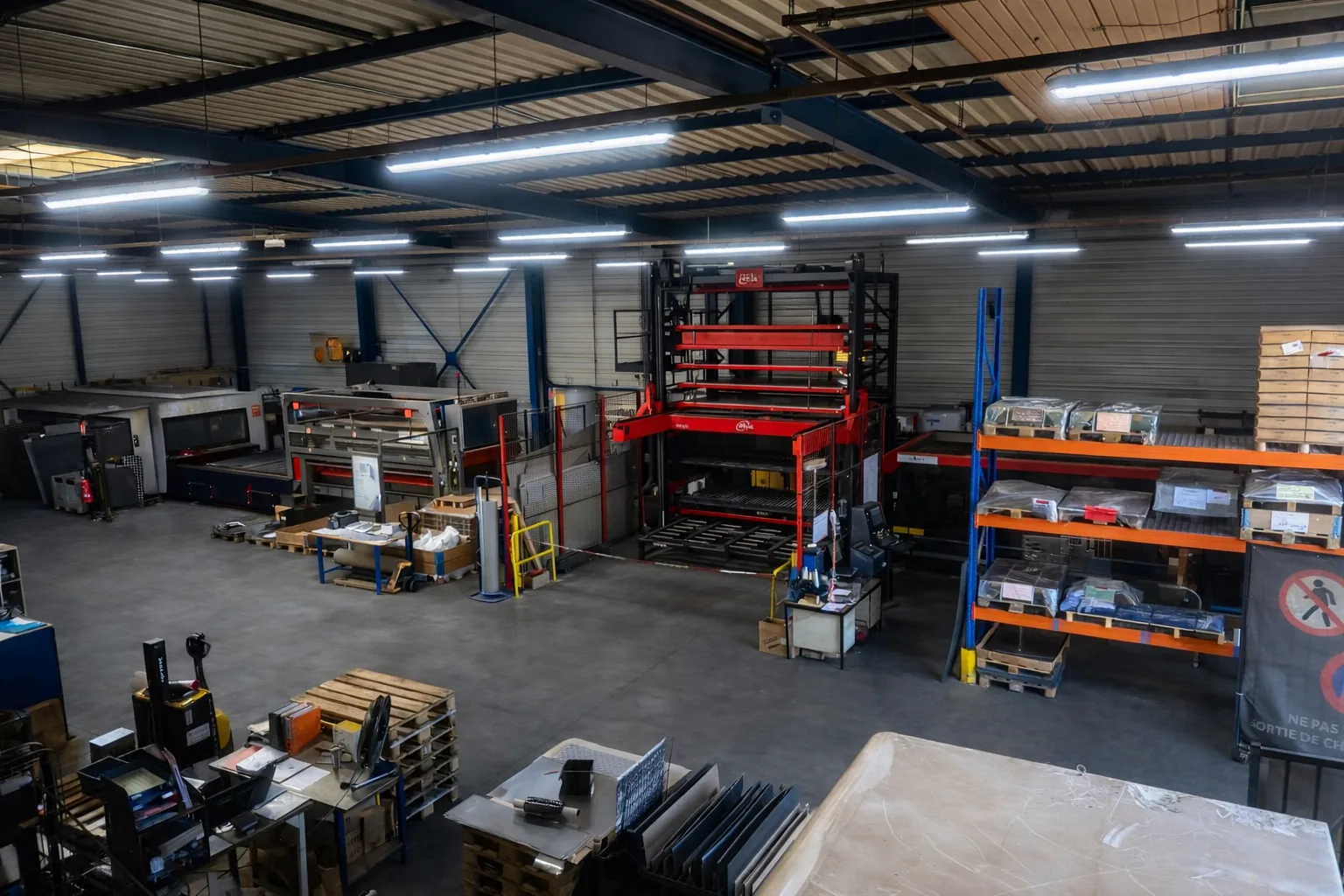 Vue d'ensemble de l'atelier AICC Microlaser à Chemaudin-et-Vaux : lasers de découpe et tour de stockage automatisée